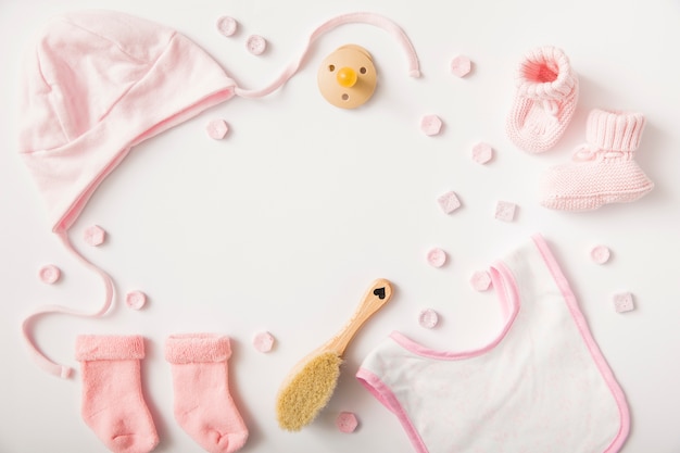 Foto dulces con ropa de bebé; cepillo y chupete aislados sobre fondo blanco