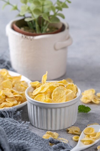 Dulces de tazón de copos de maíz con leche sobre fondo de cemento gris, concepto de diseño de desayuno fresco y saludable de cerca.