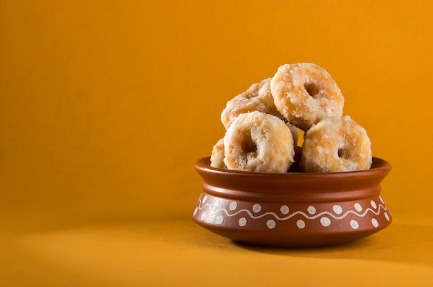 Dulces tradicionales indios Balushahi sobre un amarillo