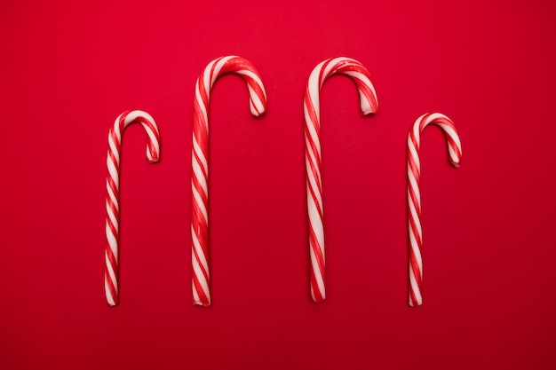 Dulces tradicionales de Navidad, dulces de bastón de caramelo sobre fondo rojo