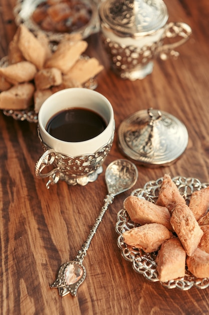 Dulces turcos con café en una mesa de madera