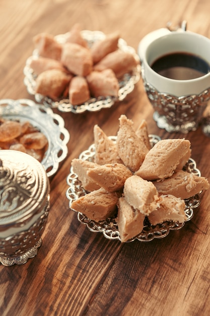 Dulces turcos con café en una mesa de madera