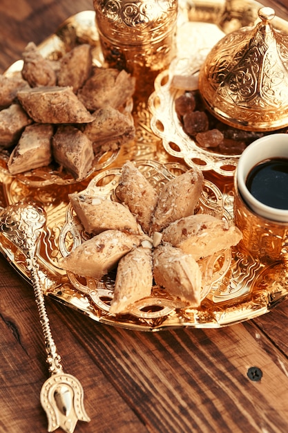 Dulces turcos con café en una mesa de madera