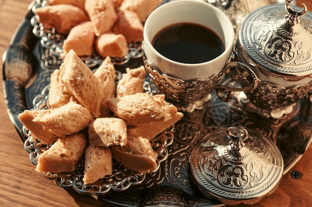 Dulces turcos con café en una mesa de madera