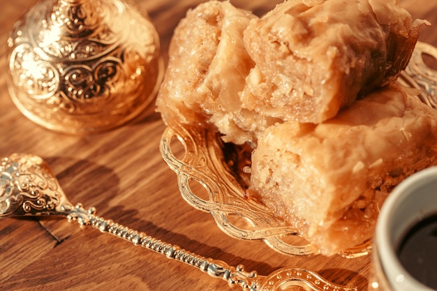 Dulces turcos con café en una mesa de madera