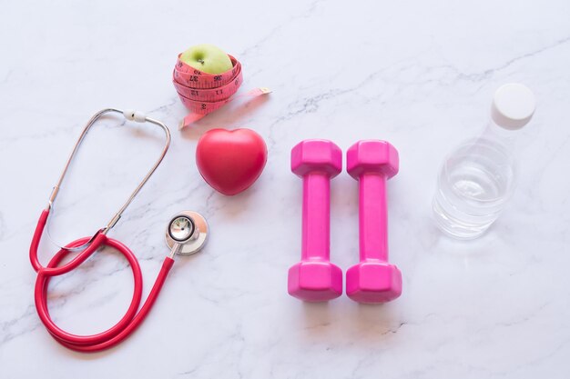 Dumbbell com forma de coração vermelho e maçã verde conceito de saúde e fitness