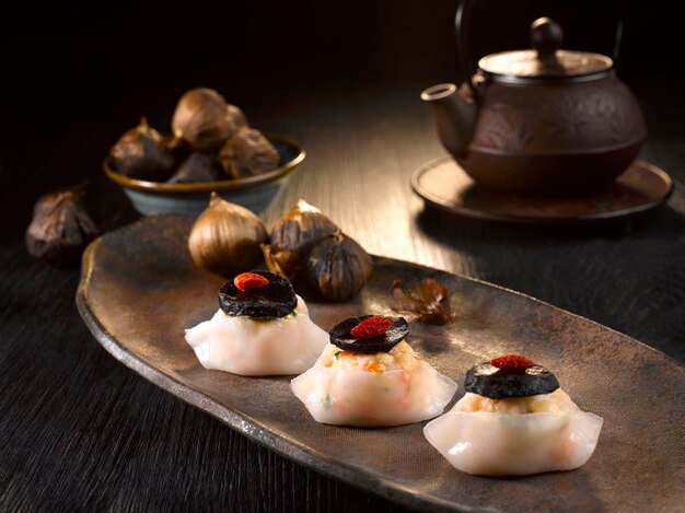 Dumpling al vapor con carne picada y ajo negro servido en un plato aislado en la vista superior de la mesa de la comida
