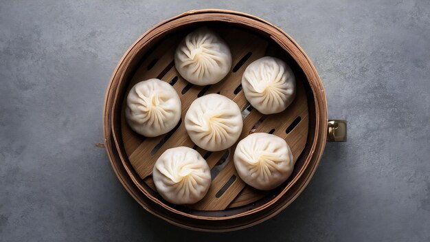 Los dumplings de baozi al vapor rellenados con carne en un vaporizador de bambú con fondo gris vista superior