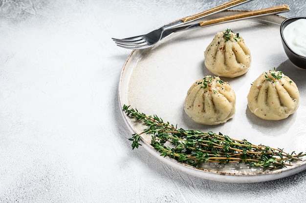 Dumplings cozinhados asiáticos manti com carne picada em um prato.