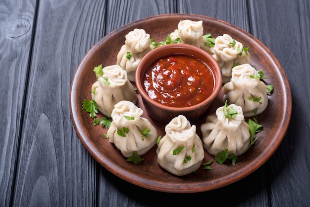 Dumplings georgianos khinkali con salsa de tomate y perejil