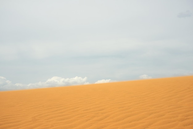 Foto duna de arena en el desierto con nubes en el fondo
