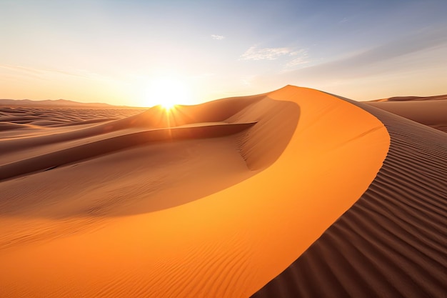 una duna de arena con la puesta de sol detrás de ella