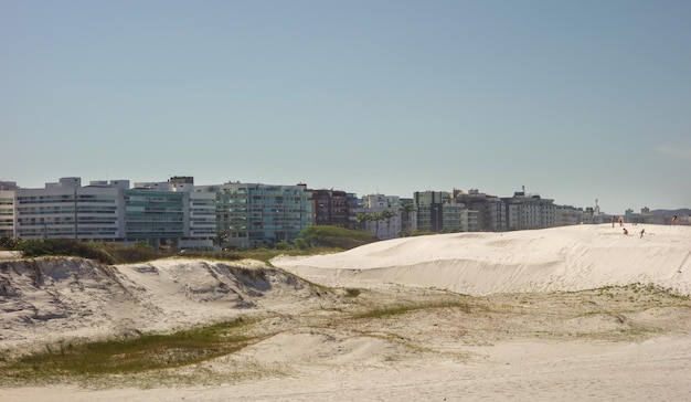 Dunas de arena y edificios frente al mar en la playa de Forte. Cabo Frío, Río de Janeiro, Brasil