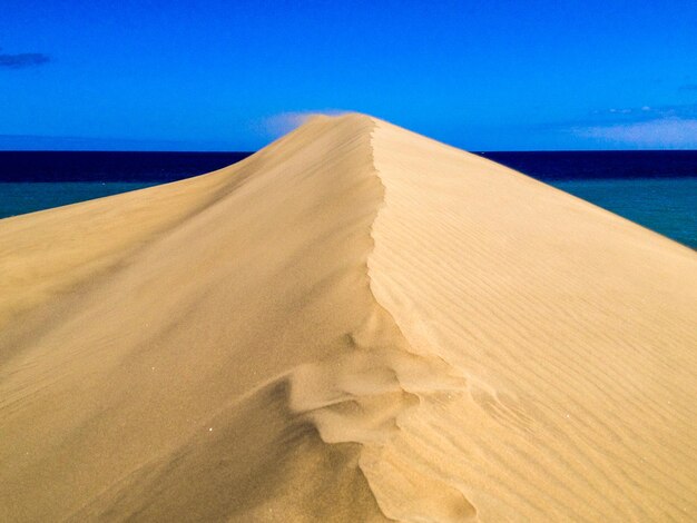 Foto dunas de areia no deserto contra o céu azul claro