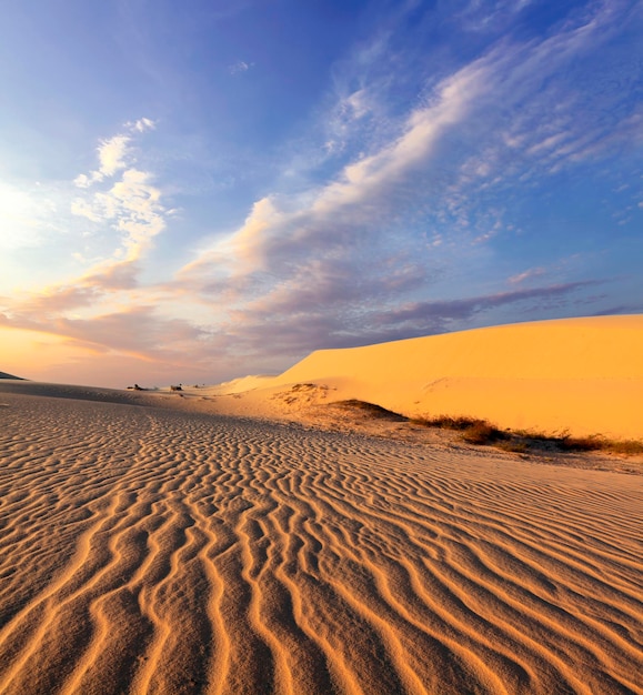 Dunas de areia perto de Mui Ne. Conjunto de off road em cima de dunas ao fundo. Dia de sol com céu azul..