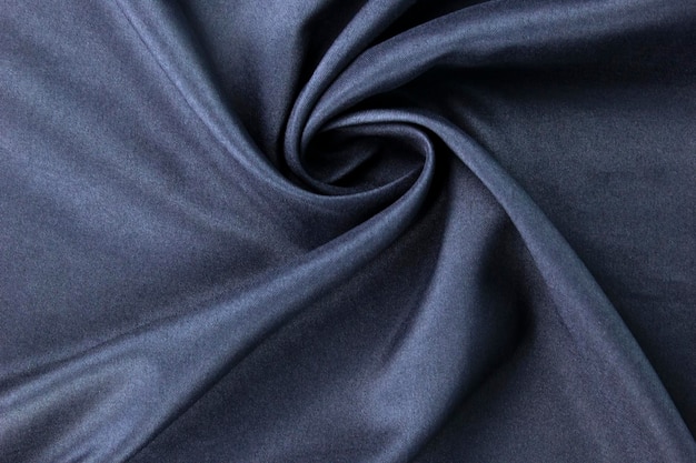 Dunkelblau wellige weiche Falten auf der Oberfläche des Stoffes blauer eleganter Hintergrund, der in Banner von Kleidung und Stoffmodekonzepten verwendet wird