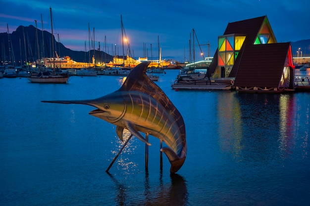 Foto dunkelblick auf den mindelo-marina kap verde mit marlin-skulpturen, segelschiffen und bergen