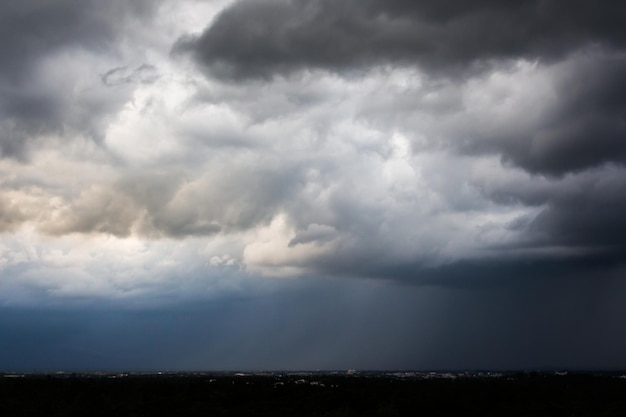 Dunkle Gewitterwolken über Wiese mit grünem Gras