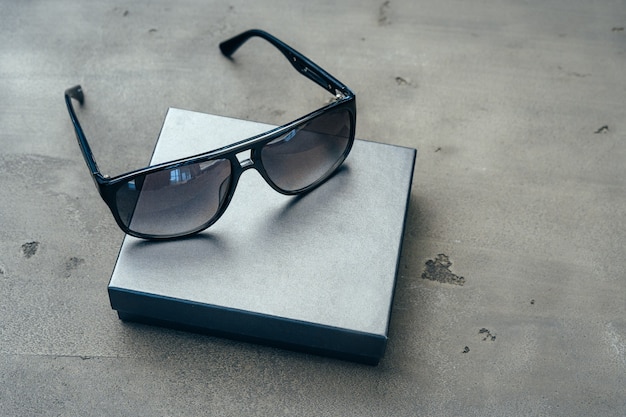 Dunkle männliche Sonnenbrille auf grauer Betonoberfläche