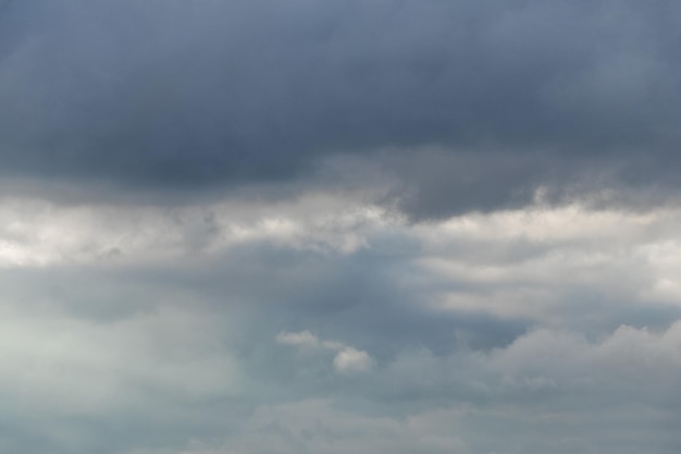 Dunkle schwere Wolken am blauen Himmel, dramatischer Himmel mit dunklen Gewitterwolken