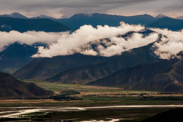 Dunkle, stimmungsvolle Landschaftsansicht von Bergen und Hügeln in Tibet