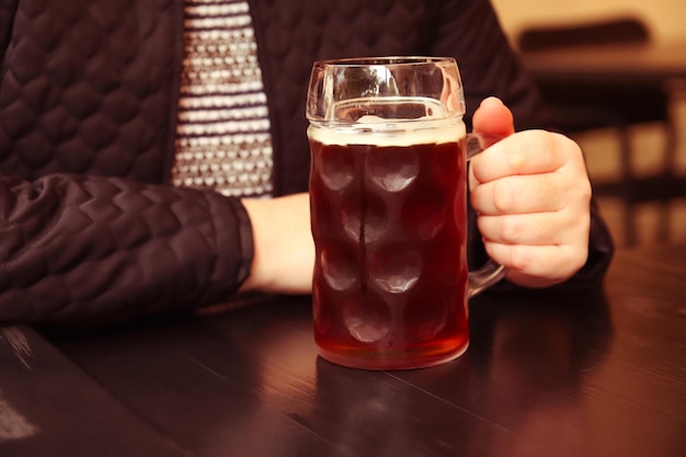 Foto dunkler bierbecher dunkler bier nahaufnahme von zwei händen klingelnde bier stein gläser menschen frau oder mann