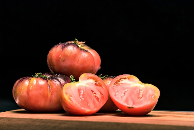 Dunkler Hintergrund der Stillleben-Tigertomaten