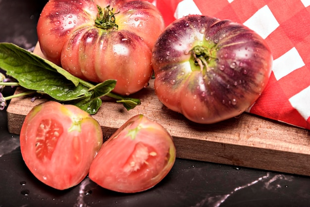 Dunkler Hintergrund der Stillleben-Tigertomaten