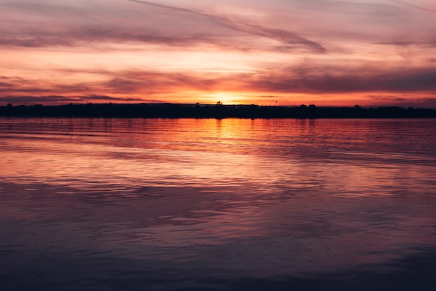 Dunkler Sonnenuntergangshimmel über dem Fluss