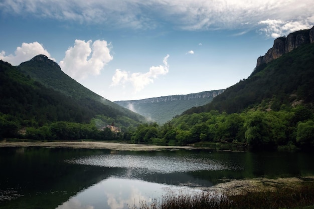 Dunkler und nebliger See mit Hügeln nach dem Regen