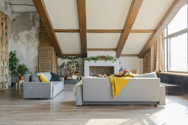 Dunkles Interieur im Loft-Stil des großen gemütlichen Landhauses. offene Wohnung mit Küchenbereich, Ruhezone und Schlafbereich. Riesige Fenster und Holzdekoration