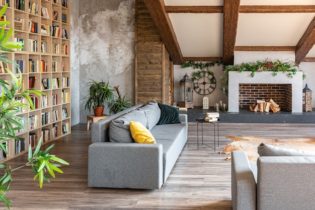 Dunkles Interieur im Loft-Stil des großen gemütlichen Landhauses. offene Wohnung mit Küchenbereich, Ruhezone und Schlafbereich. Riesige Fenster und Holzdekoration