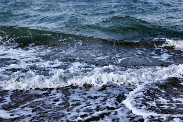 Dunkles Meer starke Wellen mit hellweißem Meeresschaum Das tobende Meer bei schlechtem Wetter