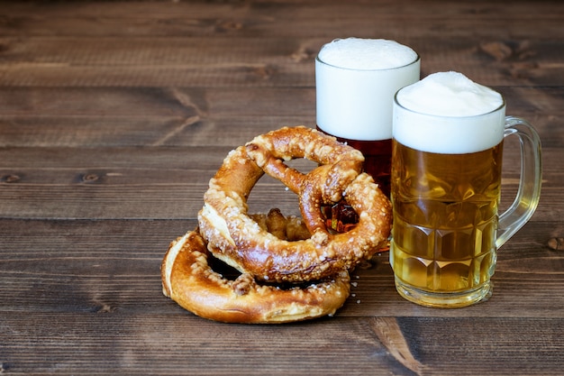 Foto dunkles und helles bier, brezeln auf dem holz