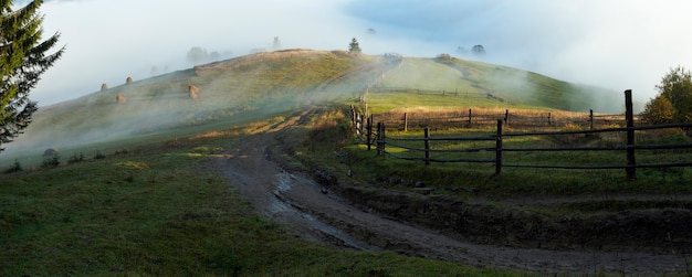 Dunstwolken bei Tagesanbruch auf Hügel und schmutzigem Roud