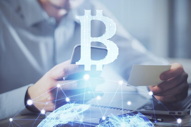 Dupla exposição das mãos do homem segurando e usando um desenho de tema blockchain de telefone e criptomoeda