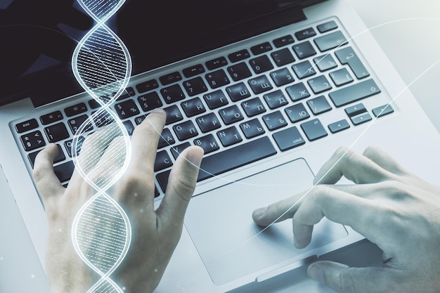 Dupla exposição de holograma de DNA criativo e mãos digitando em laptop em fundo conceito de Bioengenharia e Pesquisa de DNA