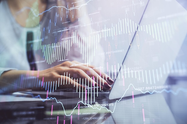 Dupla exposição de mãos femininas digitando no computador e desenho de holograma gráfico financeiro Conceito de análise do mercado de ações