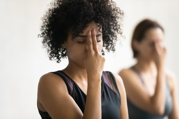 Durante a aula de ioga, as mulheres fazem prática de respiração poderosa de narinas alternadas, energizando o chakra do terceiro olho, foco de perto na mulher africana, melhora a clareza mental, aumenta a capacidade de concentrar o conceito