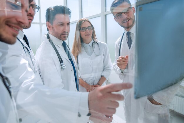 Durch das Glas steht im Büro eine Gruppe von Ärzten, die sich unterhalten