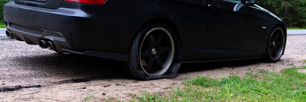 Durchbohrtes Rad eines modernen Autos auf der Straße. Reifenpanne am Auto