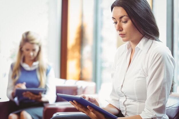 Foto durchdachte geschäftsfrauen, die digitale tablette verwenden