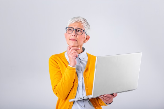 Durchdachte verwirrte reife Geschäftsfrau sorgte sich das Denken an das on-line-Problem, das Laptop, die frustrierten besorgten älteren mittleren gealterten weiblichen Leseschlechtemailnachrichten betrachtet und litt unter Gedächtnisverlust