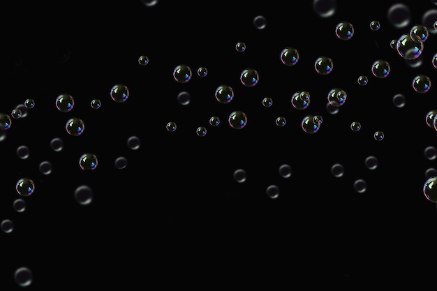 durchsichtige Seifenblasen, überlagerte Muster, abstrakte Partikel, Wasserspritzungen auf Schwarz