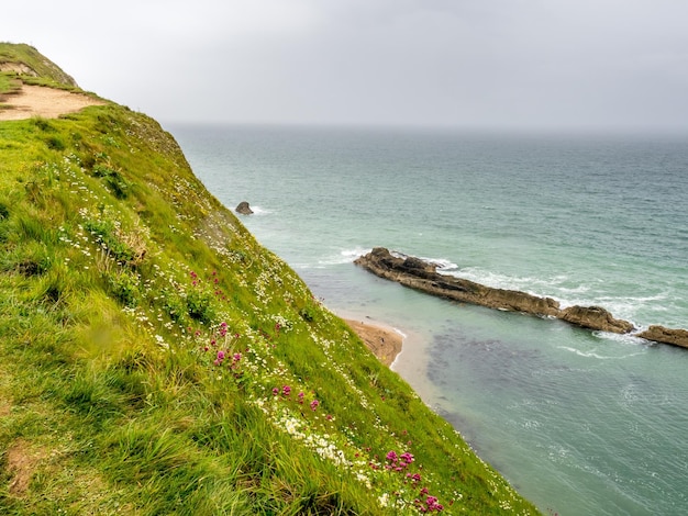 Durdle Door natürlichen Kalksteinbogen an der Küste mit der umliegenden Klippenküste in Dorset, England
