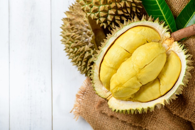 Durian fresco o Durio zibthinus Murray en saco y fondo de madera vieja, rey de la fruta de Tailandia en la temporada de verano