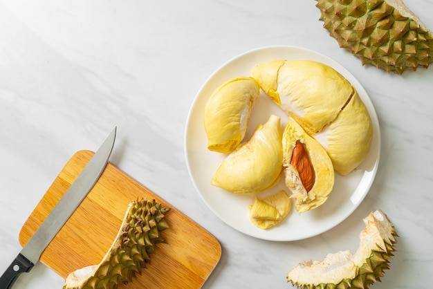 Durian maduro y fresco, cáscara de durian en la placa blanca.