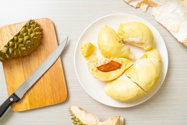 Durian maduro y fresco, cáscara de durian en la placa blanca.