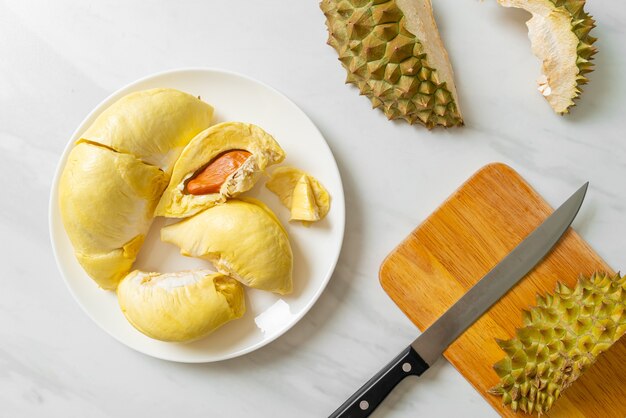 Durian maduro y fresco, cáscara de durian en la placa blanca.