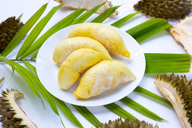 Durian en plato blanco sobre hojas verdes